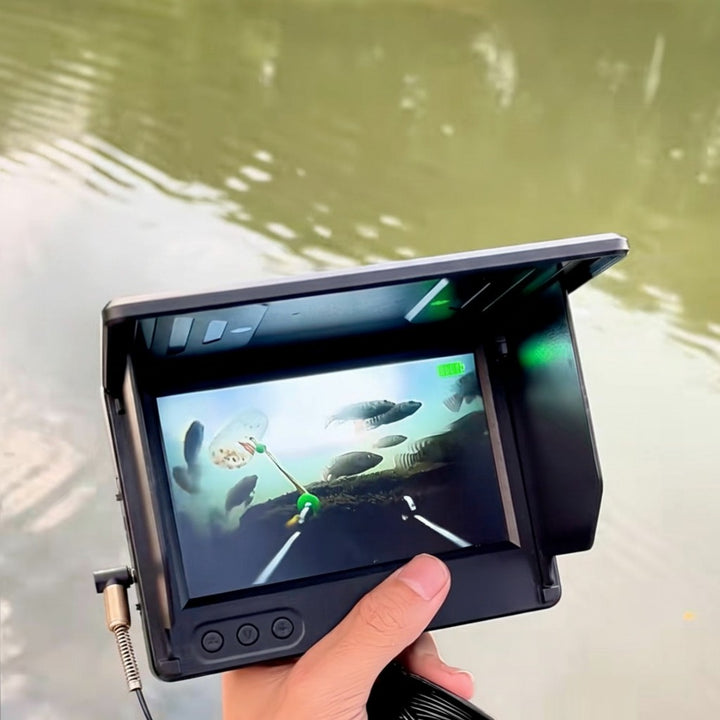 Undervattensfiskekamera i hand vid sjö med fiskbilder på skärm