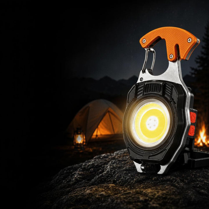 Nyckelrings-multiverktyg orange med LED-ficklampa och tändare vid campingläger