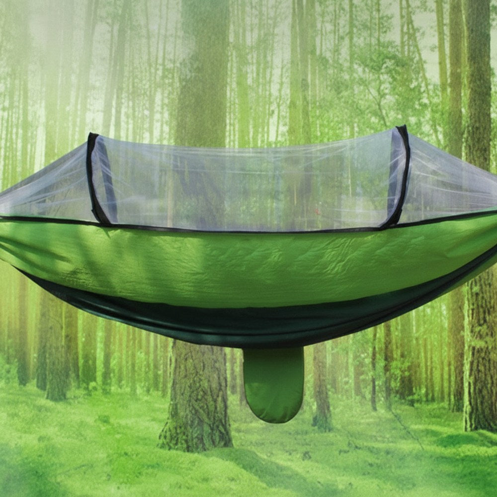 Grön campinghängmatta med myggnät i skog