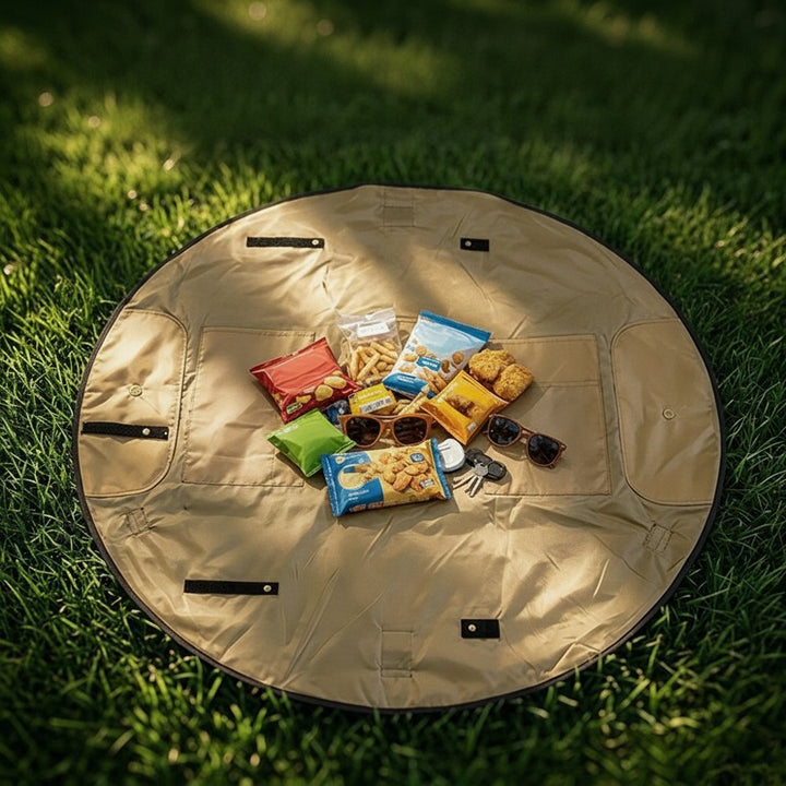 Picknickmatta utbredd på gräset med snacks och solglasögon