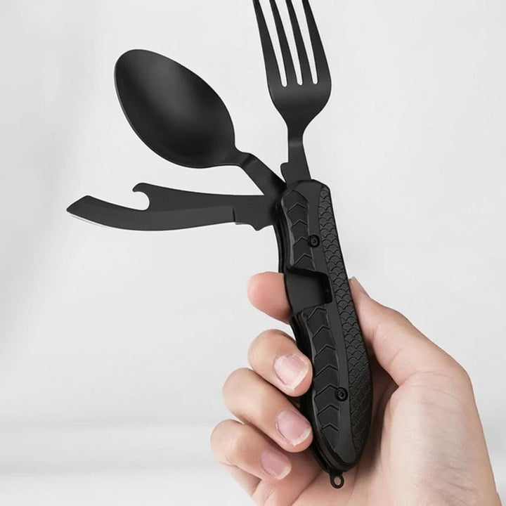 Hand håller campingbestick multitool med gaffel sked och öppnare