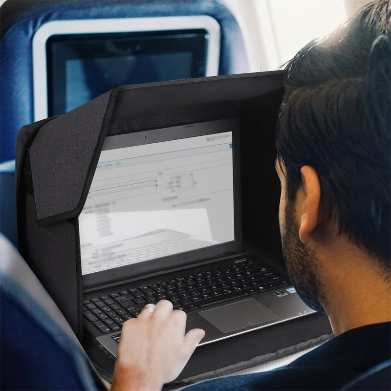 Man med laptop och solskydd på flygplanet