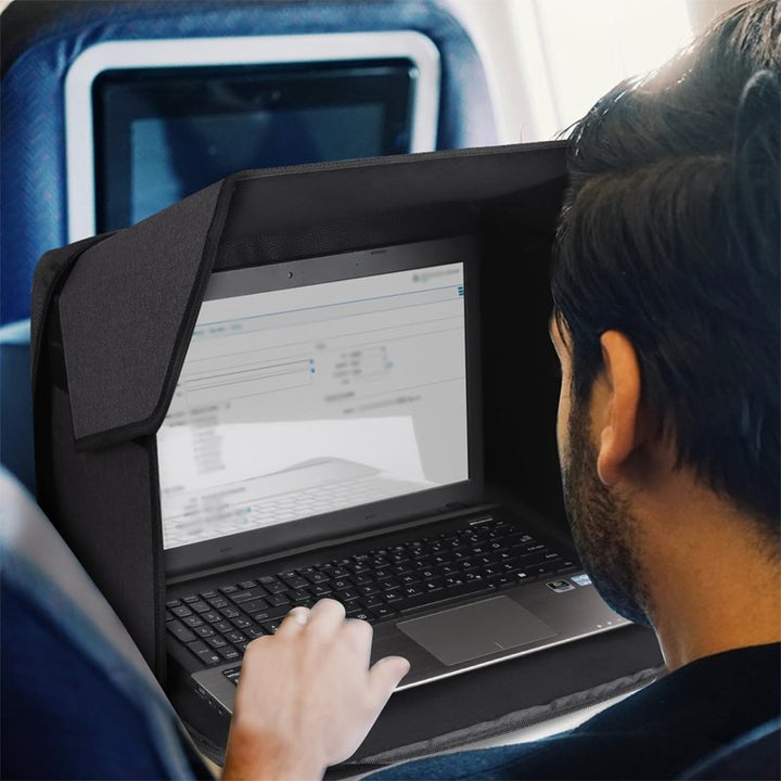 Man med laptop och solskydd på flygplanet